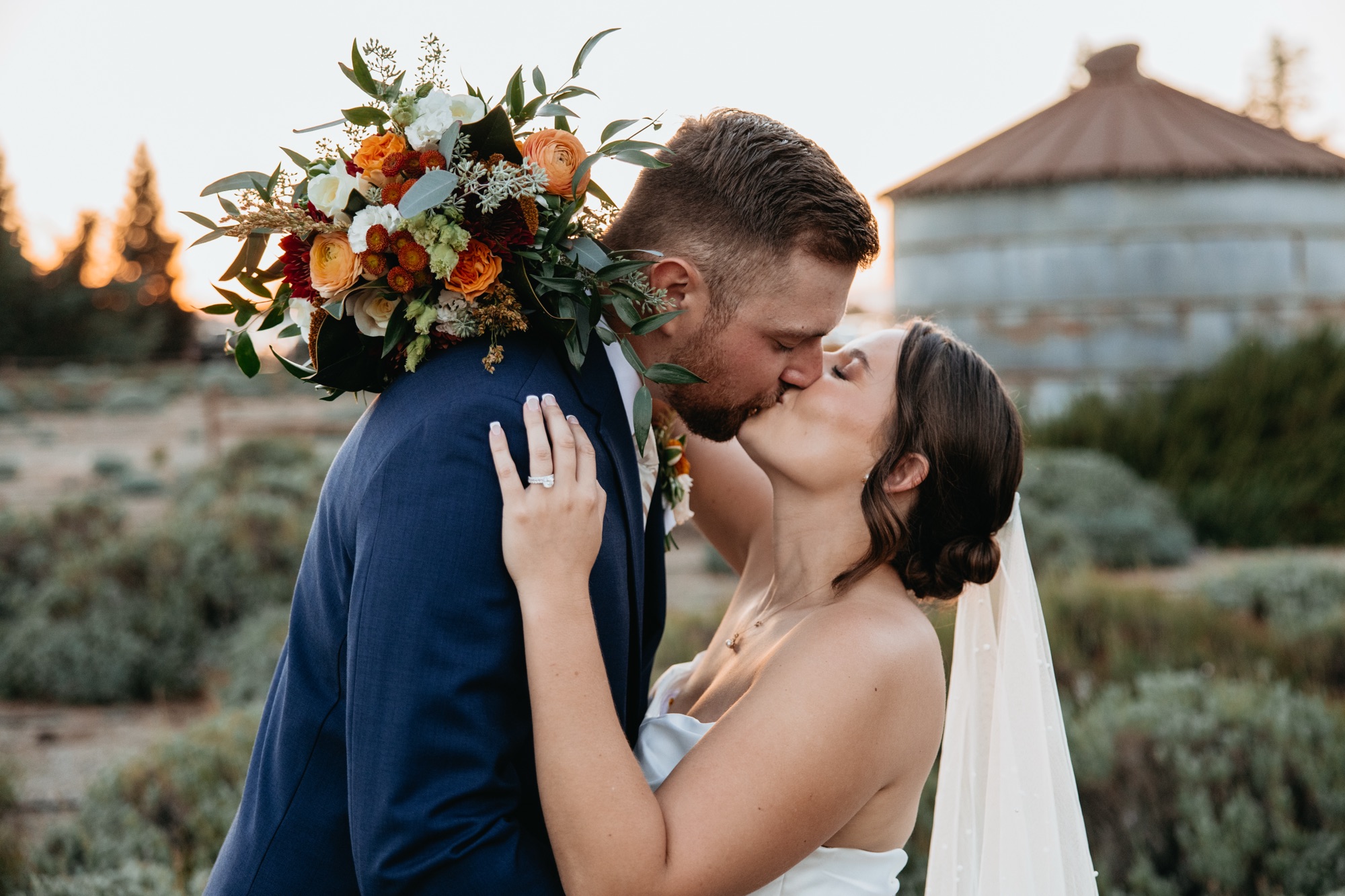 Bride and groom kissing wedding bouquet designed by Bloom & Forage at Pageo Lavender Farm in Turlock, California.